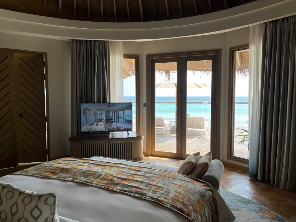 Overwater Villa Bedroom with Doors Opening Out to Pool Deck